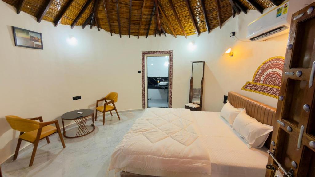 a bedroom with a bed and a table and chairs at Holiday Homestay dholavira 