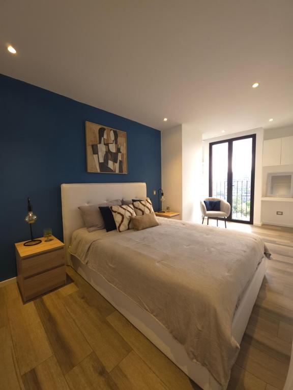 a bedroom with a large bed with a blue wall at Apartamento 2 Habitaciones, Edificio Airali, Zona 10, Florencia in Estación Pamplona
