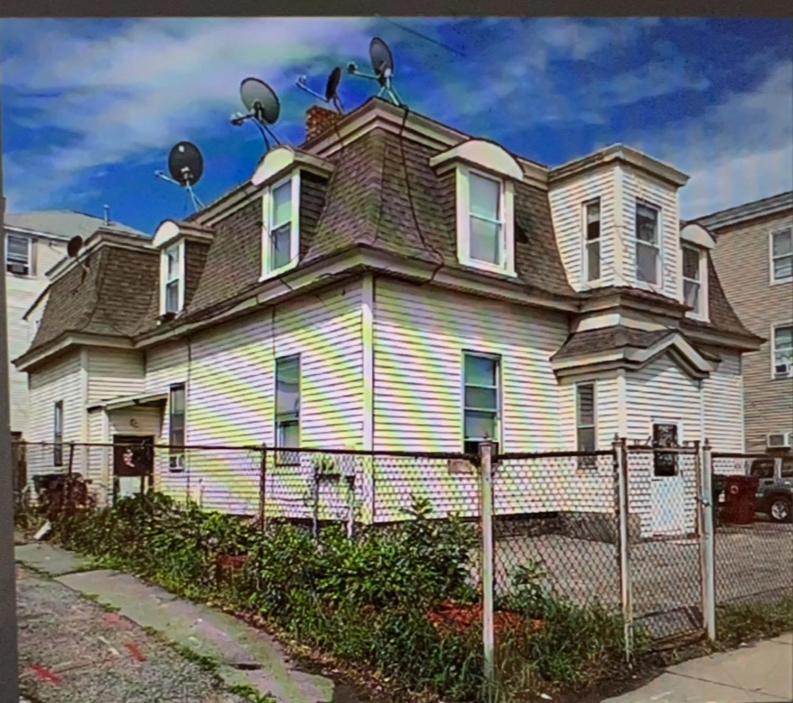 ein großes weißes Haus mit einem Zaun davor in der Unterkunft One bedroom in a 4BR apartment in Lowell in Lowell