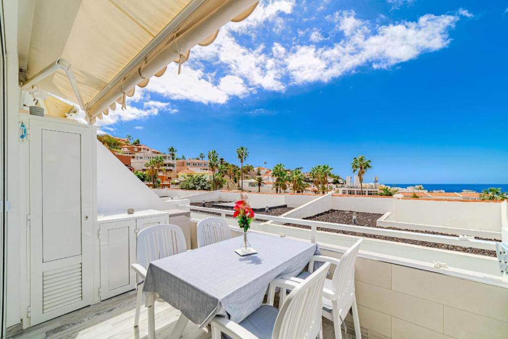 een tafel en stoelen op een balkon met uitzicht op de oceaan bij El Sueño in Adeje