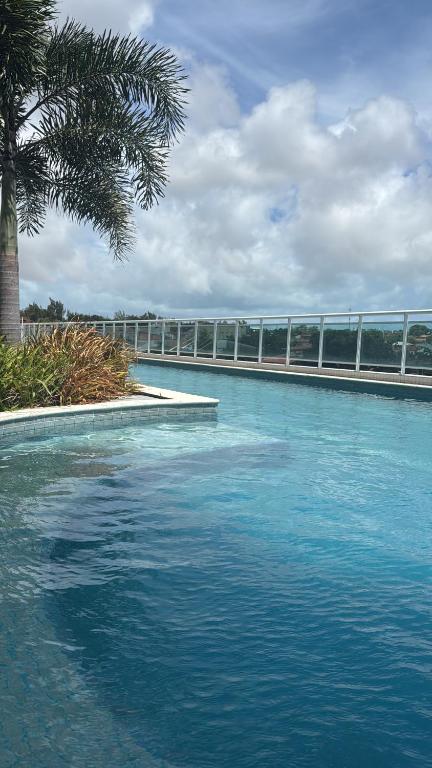 a pool of blue water with a bridge in the background at Flat aconchegante 1307 in Fortaleza