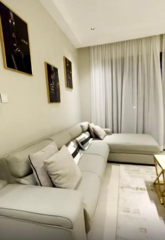 Una sala de estar blanca con un sofá y una mesa. en Lacasa Homes, en Kampala