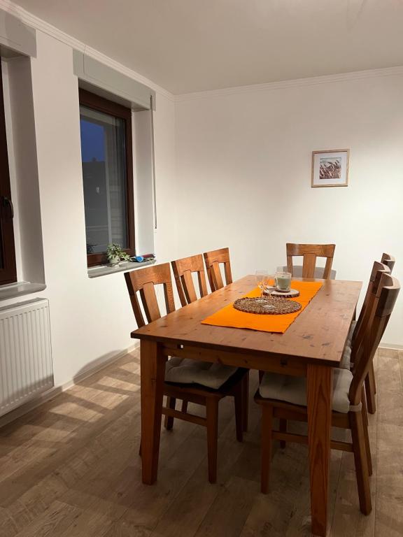 een eetkamer met een houten tafel en stoelen bij Haus am Bach in Schleiden