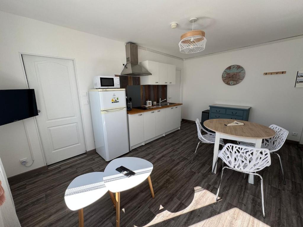 eine Küche mit Tisch und Stühlen in einem Zimmer in der Unterkunft Appartement proche de la plage in Gravelines