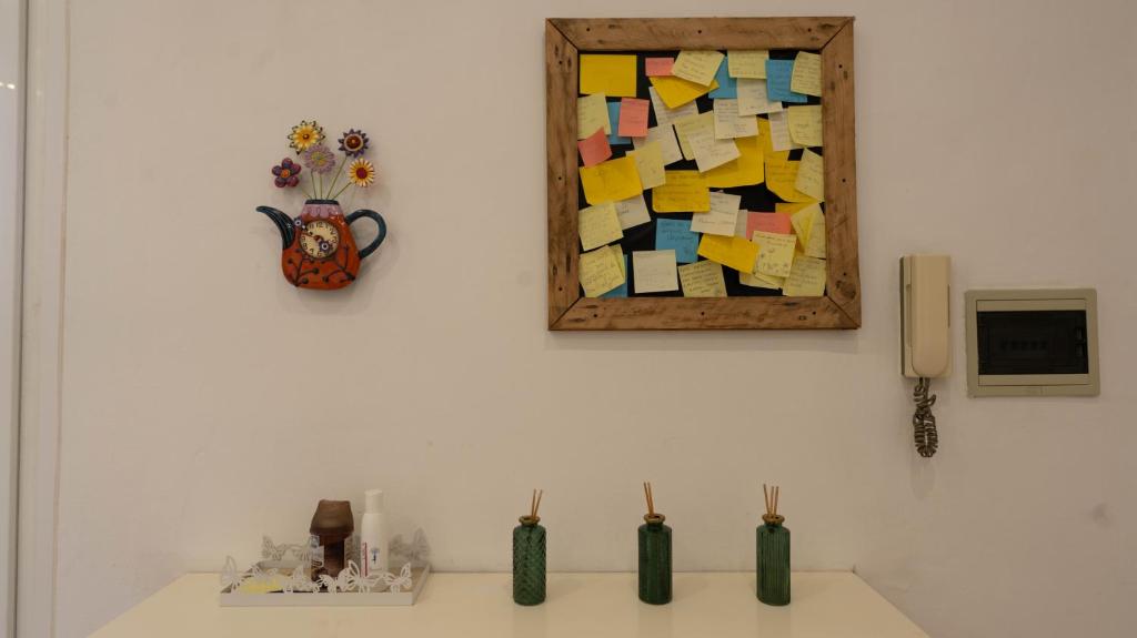 a wall with a picture and vases on a sink at Double Spaces Apartaments in Tortona