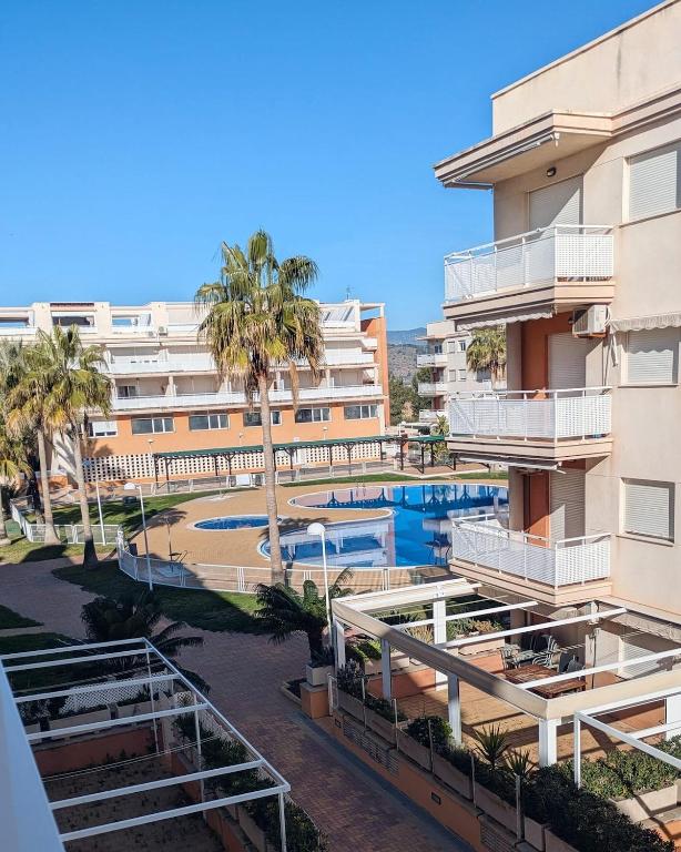 an apartment with a swimming pool and a building at Blanca Mar in Barrio-Mar