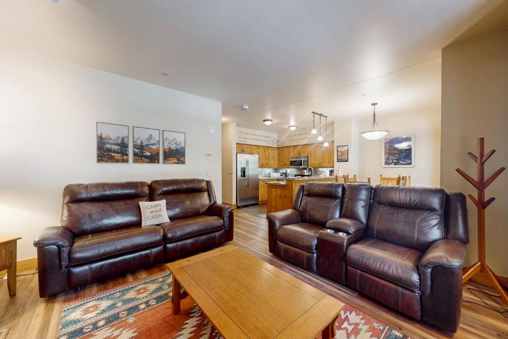 a living room with two leather couches and a table at Lodestar Cabins in Mammoth Lakes