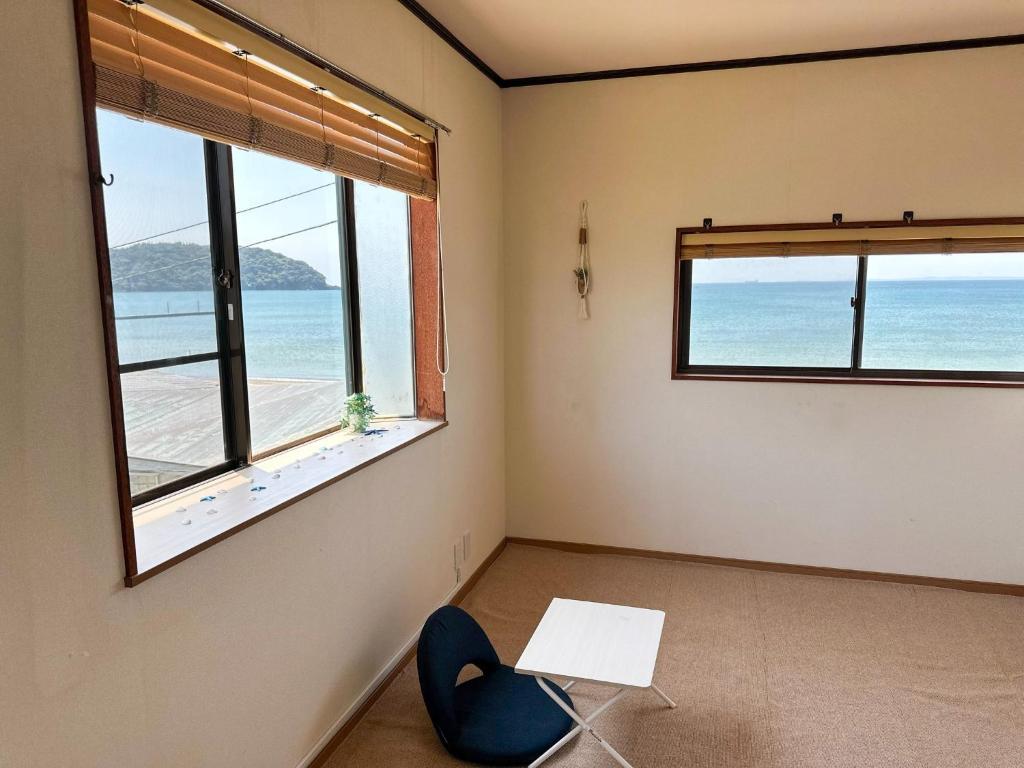 a room with a table and two windows with the ocean at kupono - Vacation STAY 00637v in Minamiboso