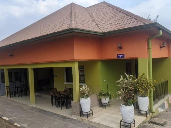 a building with tables and chairs in front of it at Glory Motel by HODAC LTD in Kigali