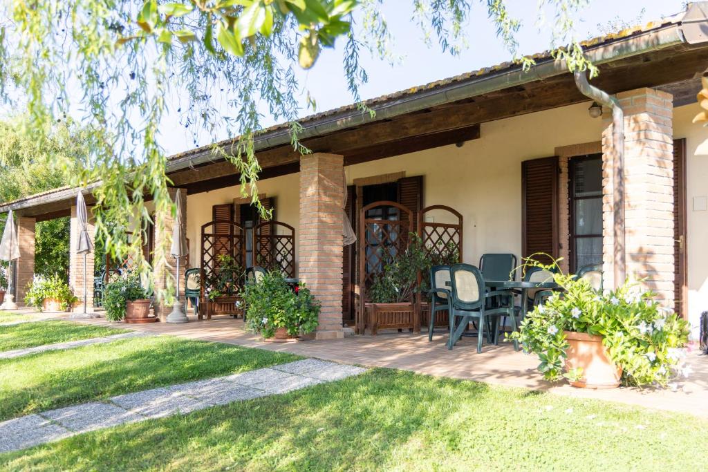 a house with a table and chairs in a yard at Agriturismo Arcobaleno in Bagno Roselle