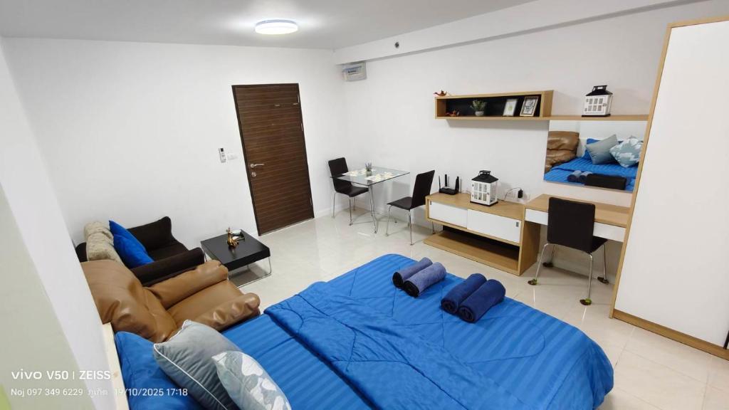 a bedroom with a blue bed and a living room at No 498 SPD in Phuket Town