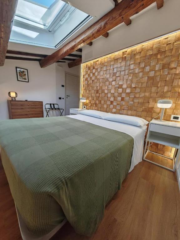 a bedroom with a large bed and a brick wall at Alkimia Apartments in Ferrara