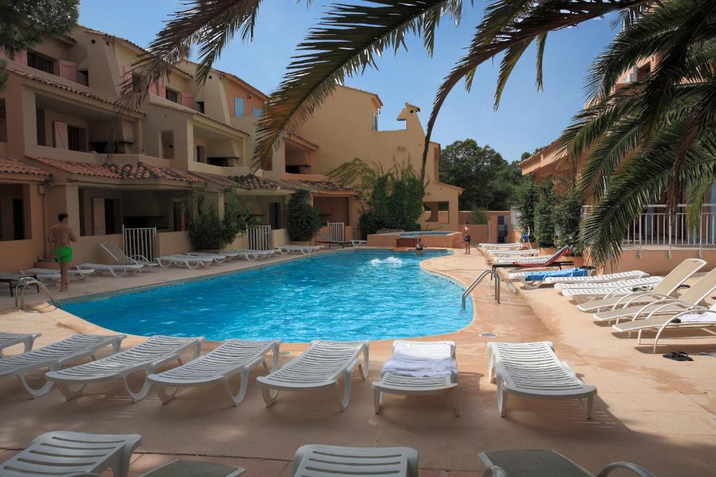 - une piscine avec des chaises longues et un complexe dans l'établissement Résidence Lago Verde, à Porto-Vecchio