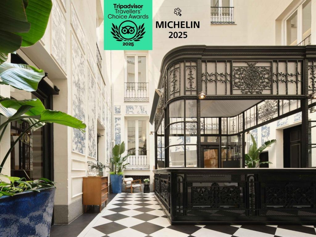 a black iron bed in a building with a checkered floor at Only YOU Boutique Hotel Madrid in Madrid