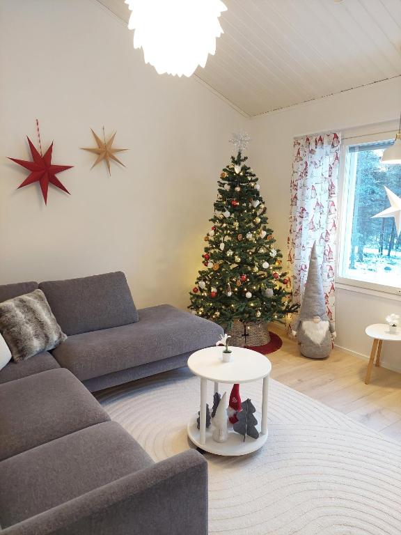 a living room with a christmas tree and a couch at House between pines 5-bedroom house with 3 toilets in Rovaniemi