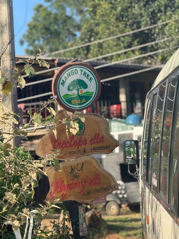 a sign for a mushroom tree restaurant next to a bus at Mango tree ella in Ella