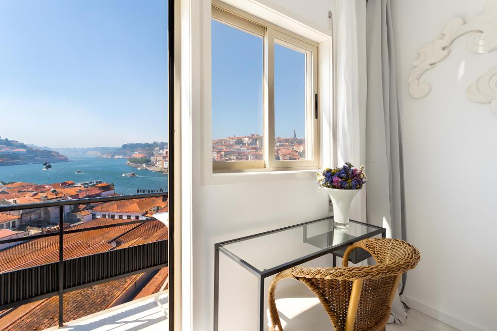 a glass table and a chair in a room with a window at Vegan Topfloor - Douro e Ribeira in Bandeira