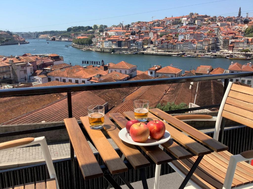 a plate of apples and drinks on a table on a balcony at Vegan Pátio - Douro e Ribeira in Bandeira