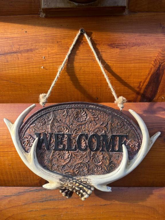 a sign with the word welcome hanging on a wall at Cozy Lake Cabin in Eagle Rock