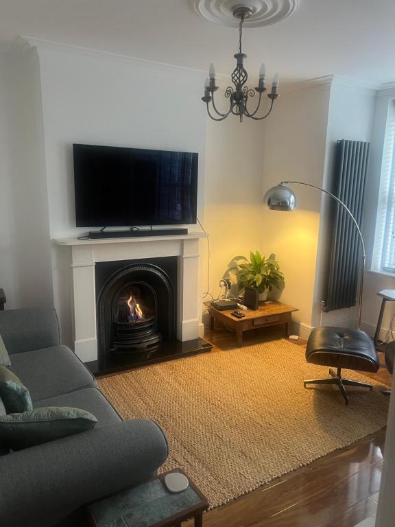 a living room with a couch and a fireplace with a television at Luxury apartment with 2-Beds in Beckenham