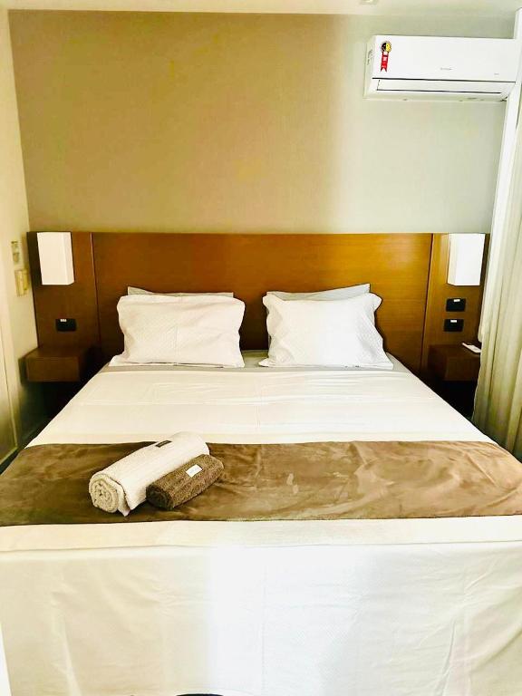 a hotel room with a bed with a towel on it at Studio Completo - Vila Olímpia - Moema in São Paulo