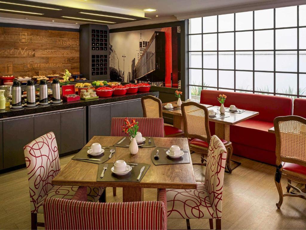 a restaurant with two tables and chairs and a counter at Mercure Sao Paulo Alamedas in Sao Paulo
