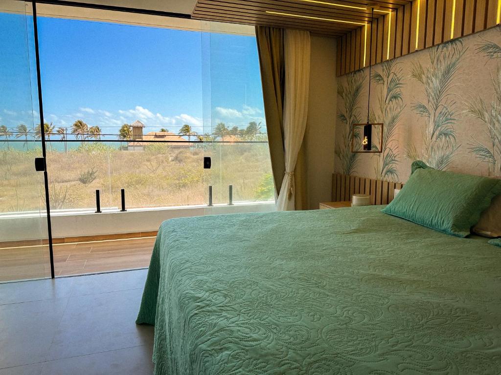 a bedroom with a large bed and a large window at Casa Som das Ondas in Fortim