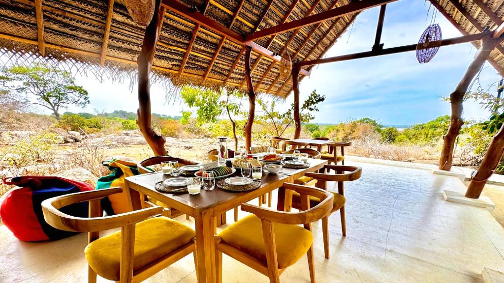 a dining room with a table and chairs on a patio at Enchanted Escapes Yala in Yala