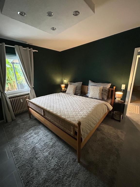 萨尔堡Palmen Oase, Relax & Wellness Saarburg的一间卧室设有一张大床和绿色的墙壁