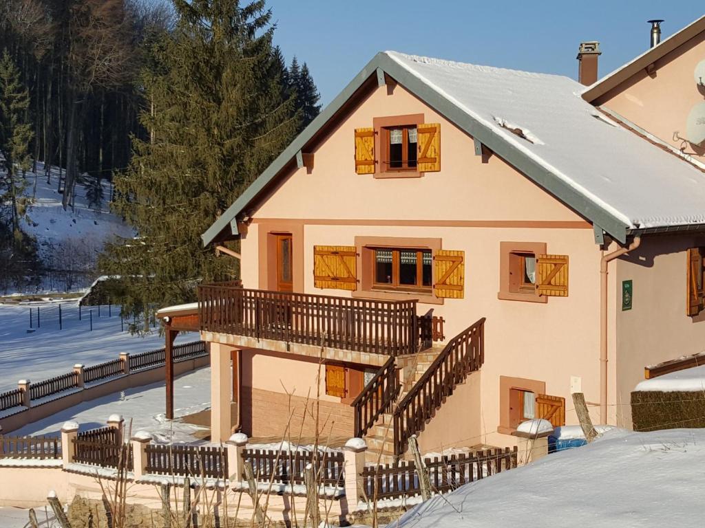 a house with a deck in the snow at Gîte familial avec piscine, idéal pour randonnées et pêche, proche Gérardmer et crêtes vosgiennes - FR-1-589-238 in Vienville