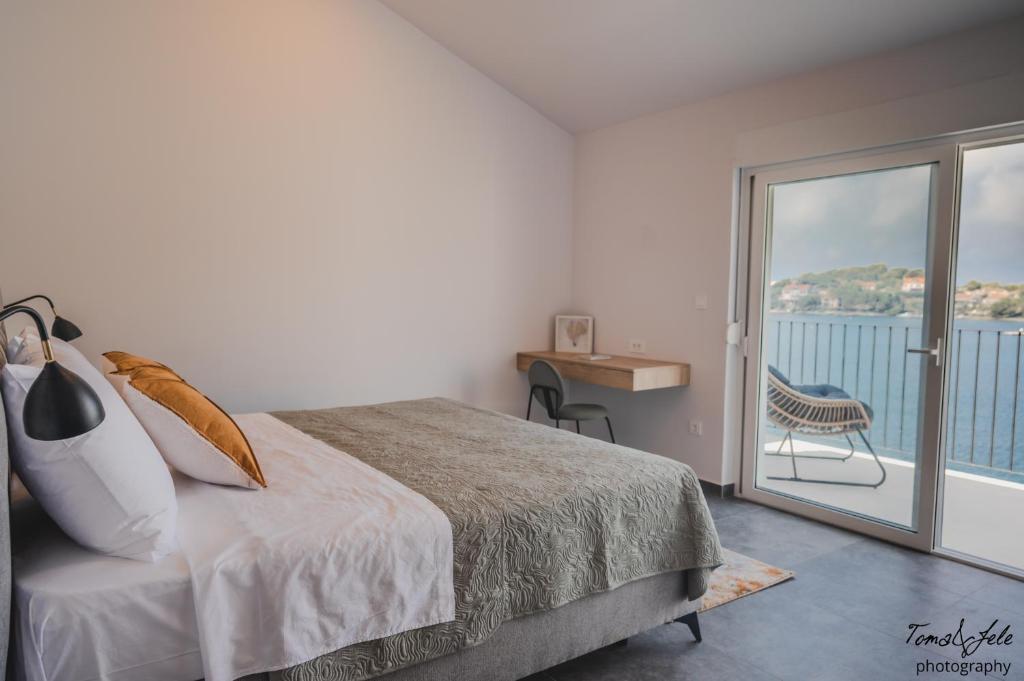 ein Schlafzimmer mit einem Bett und einem Balkon in der Unterkunft Discover Lastovo premium accommodation in Skrivena Luka