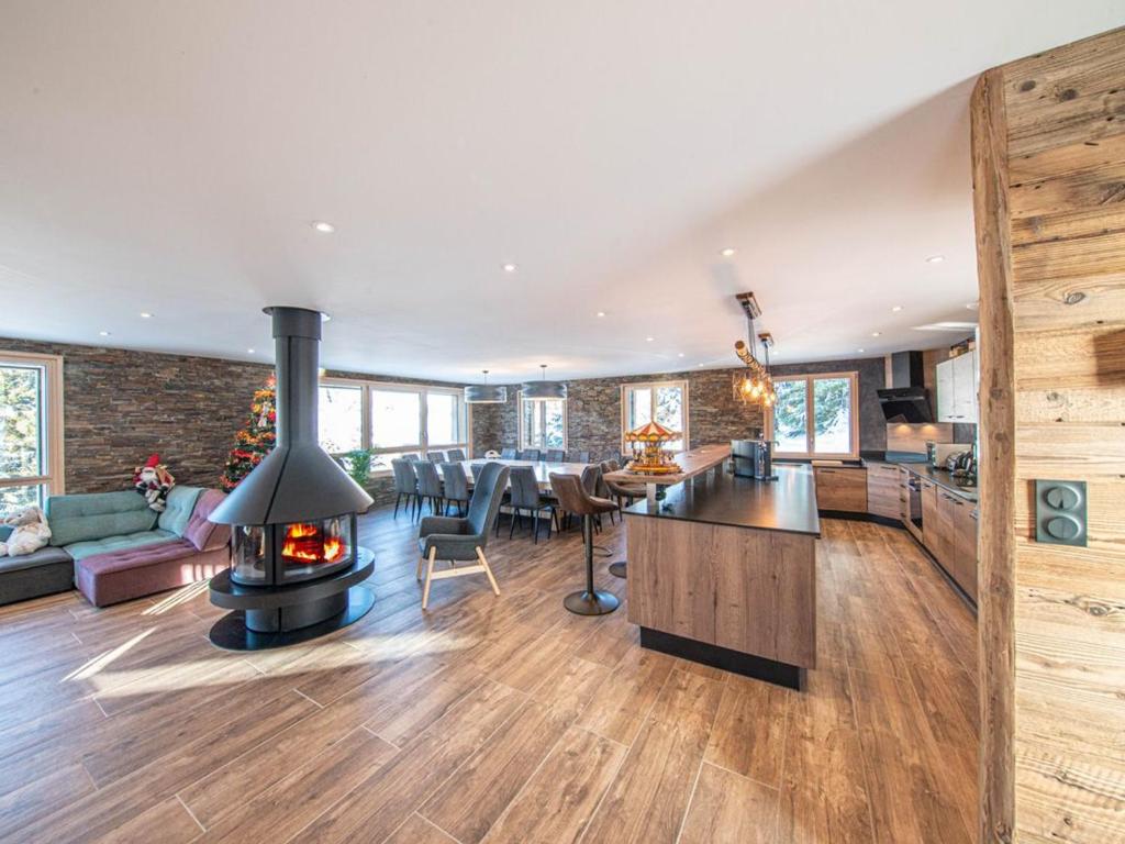 a kitchen and living room with a fireplace in a house at Chalet familial spacieux avec SPA, salle de jeux, près des pistes - 14 pers, Vosges - FR-1-589-366 in Ban-sur-Meurthe-Clefcy
