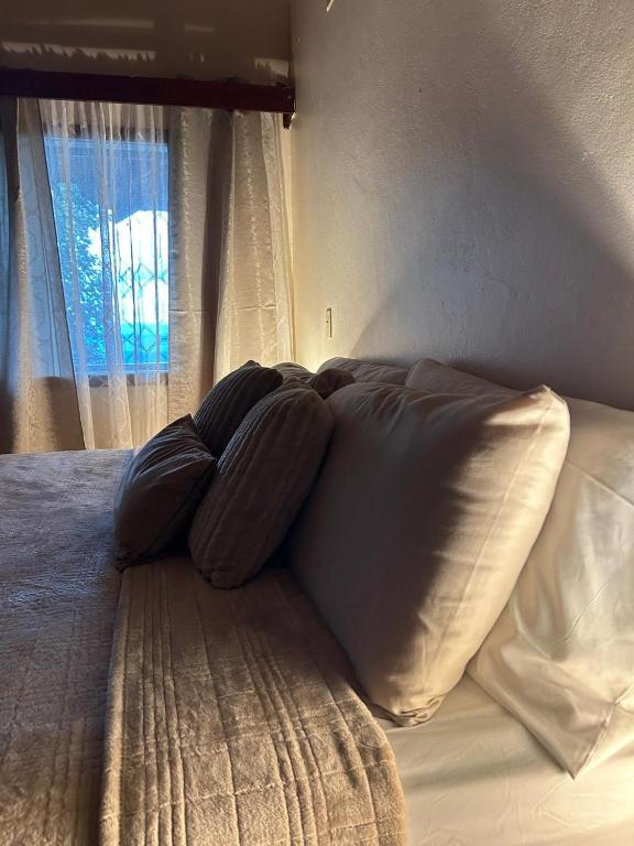un letto con quattro cuscini e una finestra di Santa Lucia Bed&Breakfast a Santa Lucía