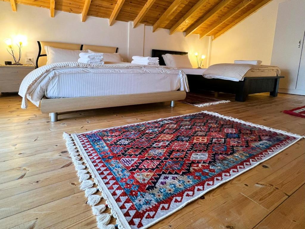 a bedroom with two beds and a rug on the floor at Vila Hysaj in Kamëz