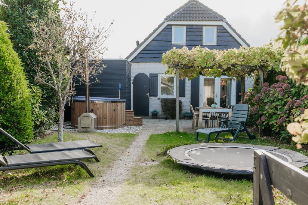 a backyard with a table and a trampoline at Vakantiehuisje met ruime tuin en hottub in Ouddorp