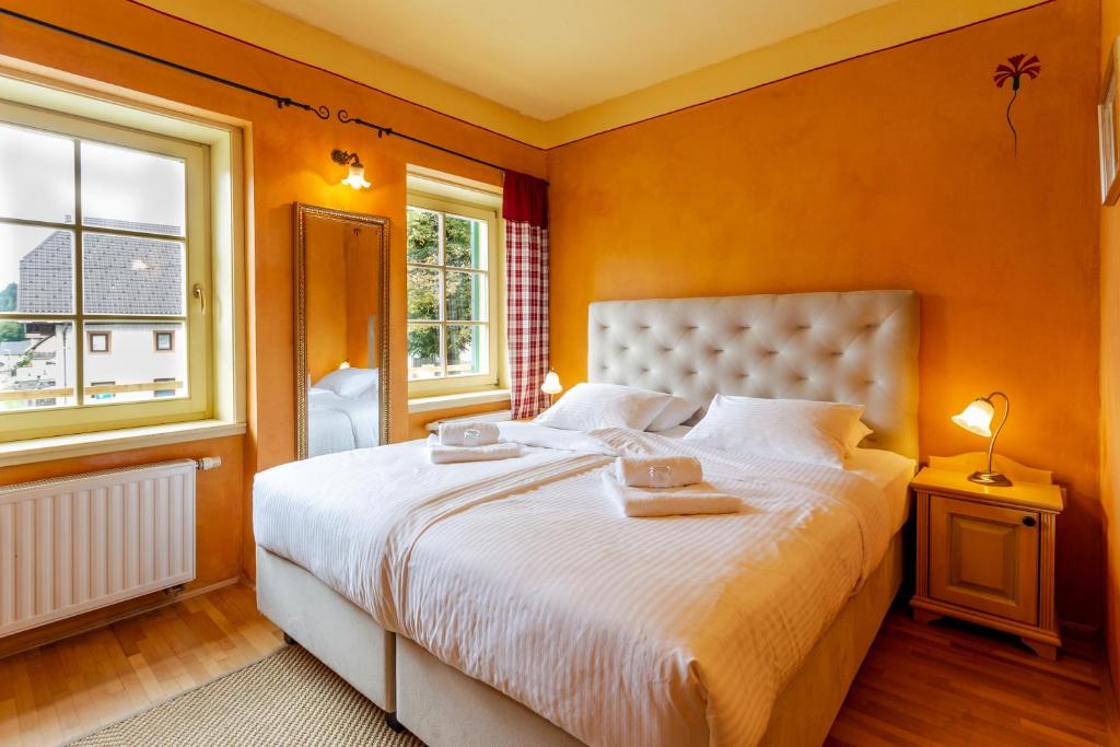 a bedroom with a large bed with orange walls at Pod Gora Boutique Hotel in Kranjska Gora