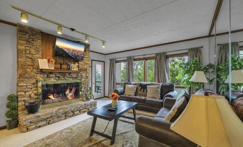 Una sala de estar con un sofá y una chimenea. en Misty Mountain By Beyond Expectations W Hot Tub, en Gatlinburg