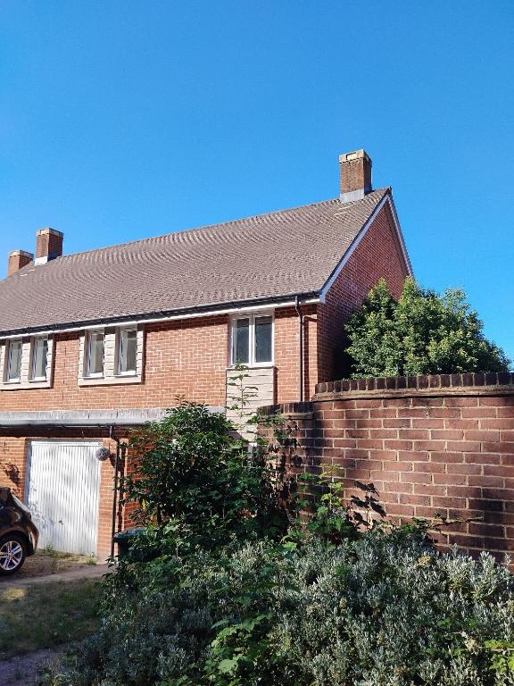 a red brick house with a brick wall at Home stay in Basingstoke