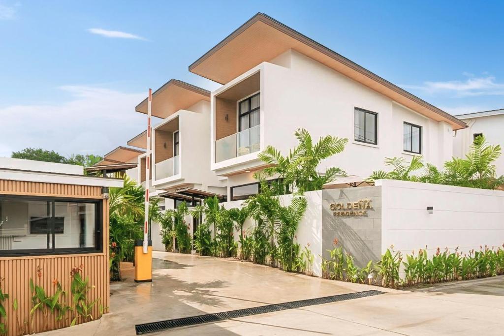 a white house with a fence in front of it at Goldena Residence Private Pool Villas in Kamala Beach