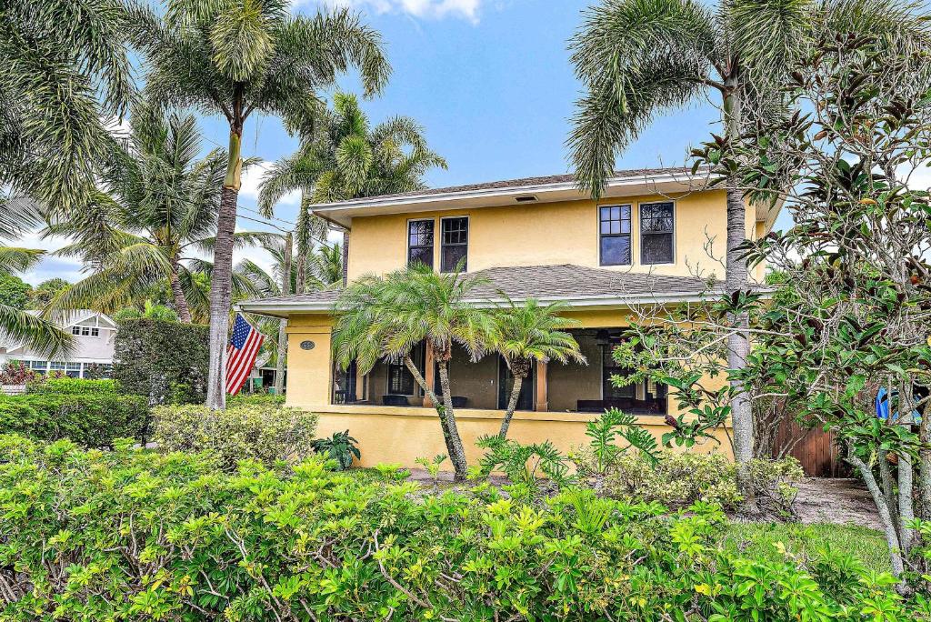 ウェストパームビーチにあるPalm Haven - Tropical Chic Home with Pool in Grandview Heightsのヤシの木が目の前に広がる黄色い家