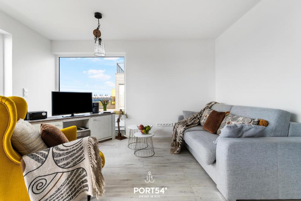 a living room with a couch and a tv at Ferienwohnung Albatros Olpenitz in Olpenitzdorf