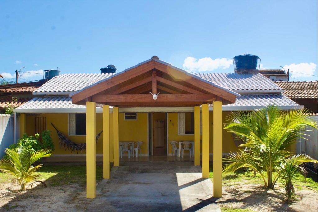 a yellow house with a wooden roof at Recanto do Rey in Mucuri