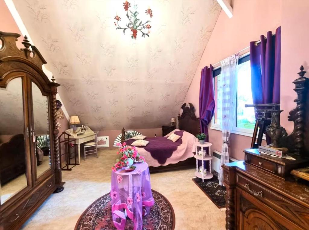 a bedroom with a bed and a table in a room at Les bosquets chambre d hôtes in Caugé