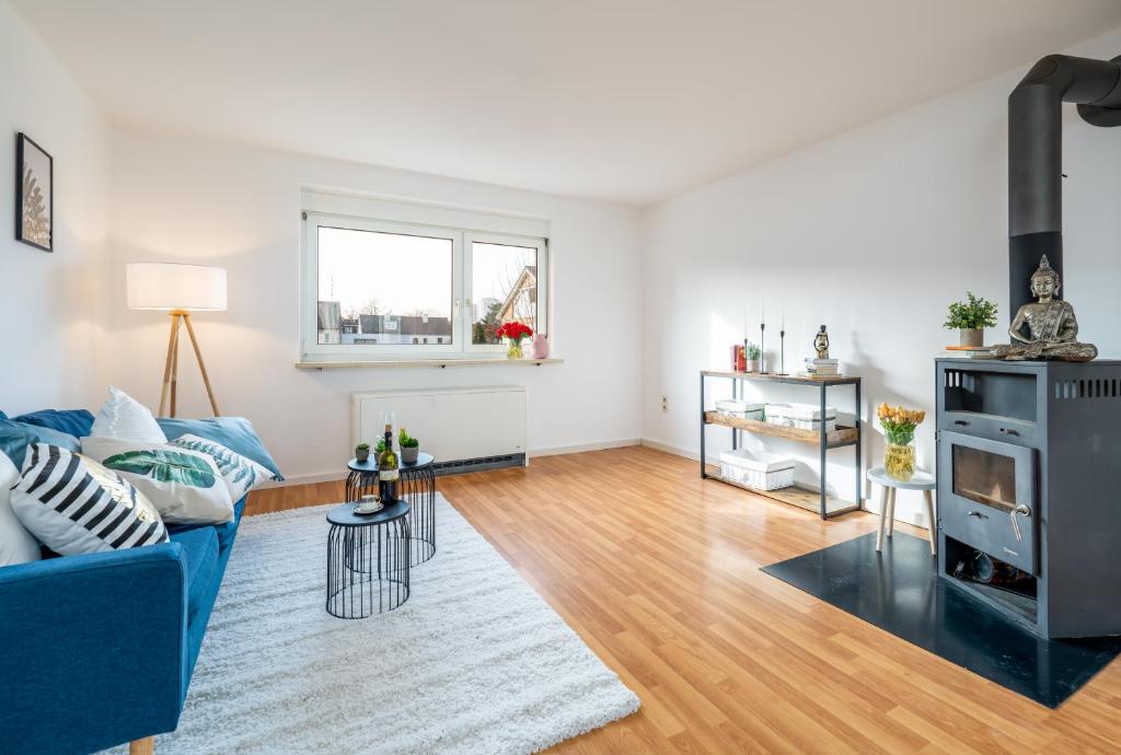 Una sala de estar con un sofá azul y una chimenea. en Nice apartment in central Dachau, en Dachau