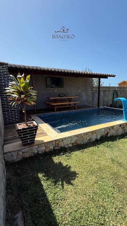 a swimming pool with a table and a potted plant at Bangalô raizes in São Gonçalo do Amarante