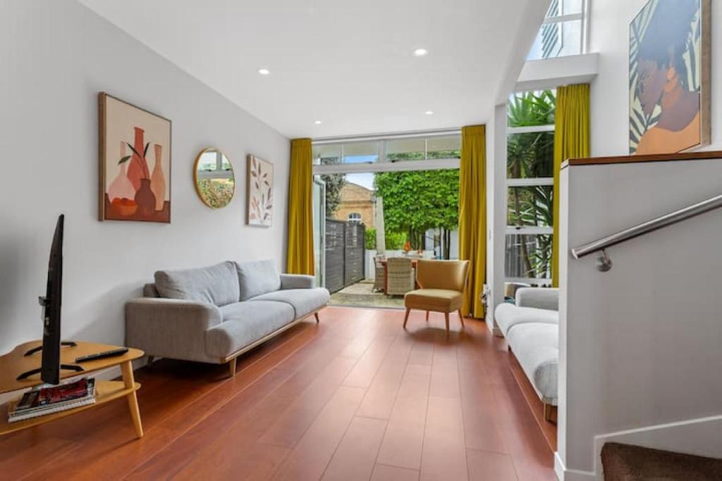 een woonkamer met een bank en een tafel bij QV Stays Modern Spacious Multi-Level Townhouse in Auckland