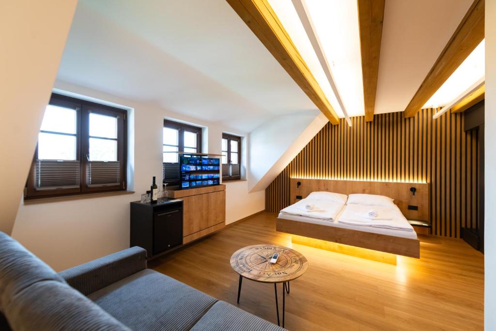 a bedroom with a bed and a couch and a table at Husí plácek s vinným sklepem a terasou in Dolní Věstonice
