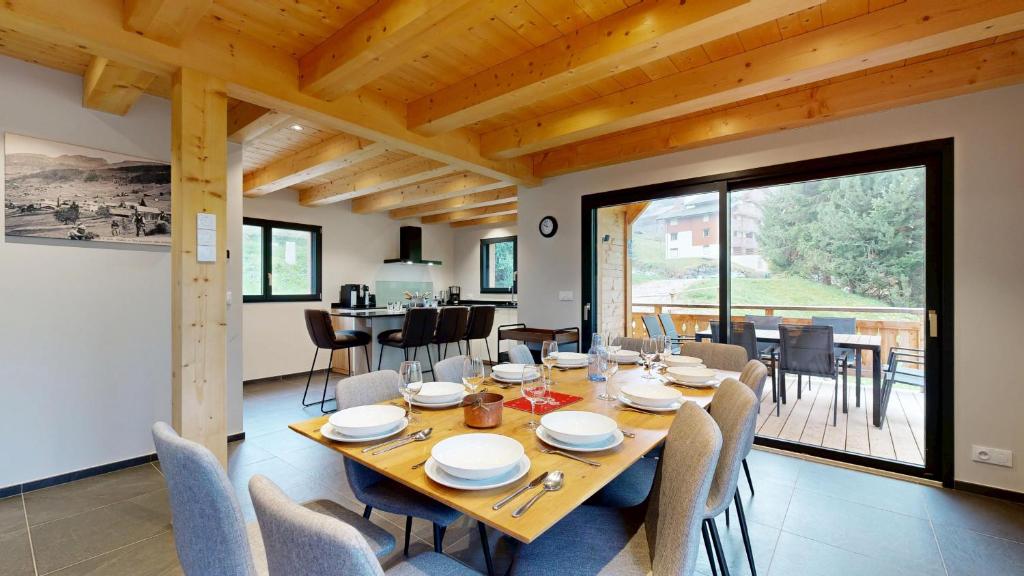 ein Esszimmer mit einem Holztisch und Stühlen in der Unterkunft Chalet La Frenaie FRN NATURE & MODERN 10 Pers in Châtel