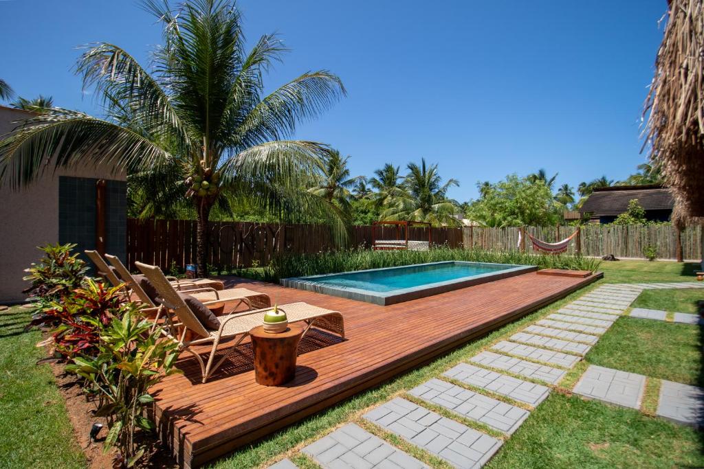 a backyard with a wooden deck and a swimming pool at Kokoye Boutique Hotel in Pôrto de Pedras
