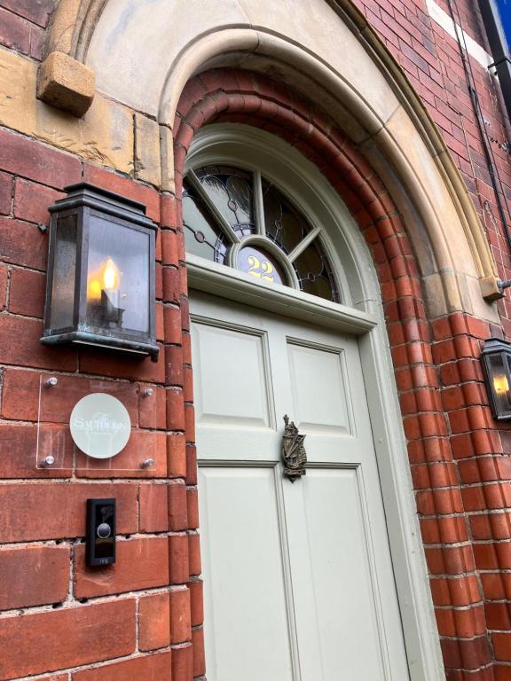 a door in a brick building with a candle on it at The Saltburn Townhouse in Saltburn-by-the-Sea